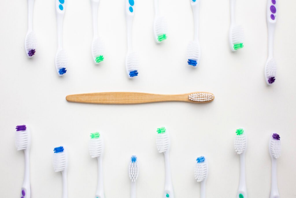 Bir grup plastik diş fırçası arasında yer alan bambu saplı sürdürülebilir diş fırçası